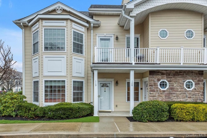 View of front of house featuring a balcony and stone siding