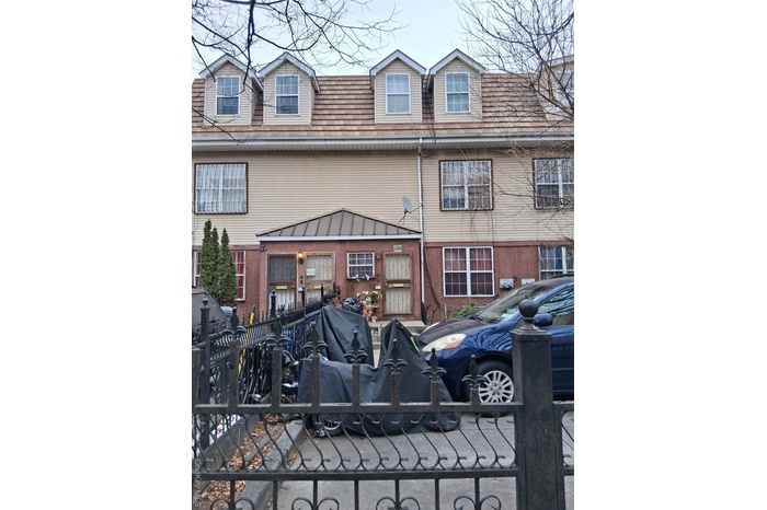 View of front facade featuring brick siding and a fenced front yard
