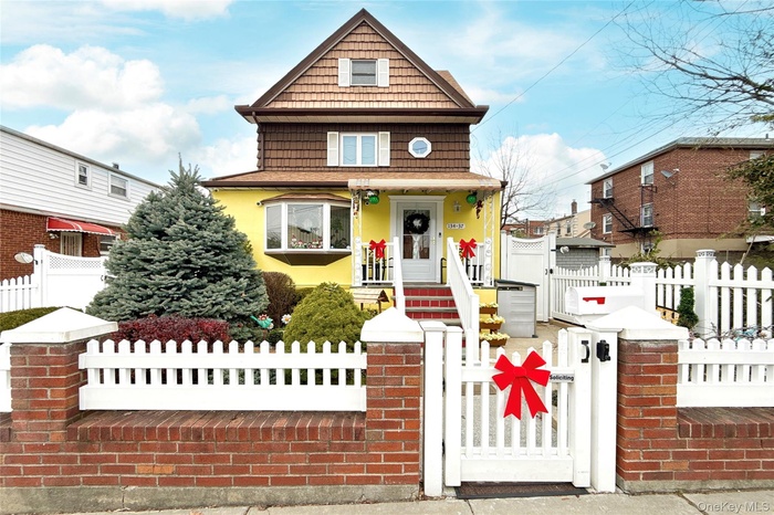View of front of property with a gate, a fenced front yard, a porch, and stucco siding