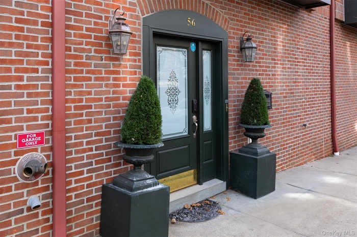 Doorway to property featuring brick siding
