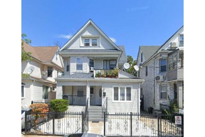 View of front of house featuring a porch, a fenced front yard, and a gate