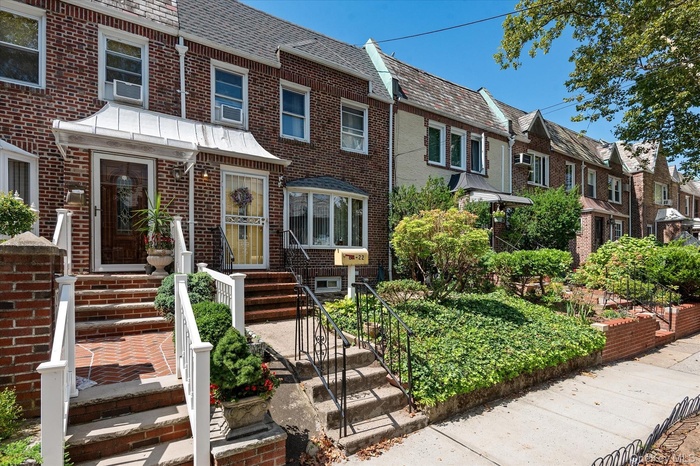 View of front of property featuring brick siding, a residential view, and a high end roof