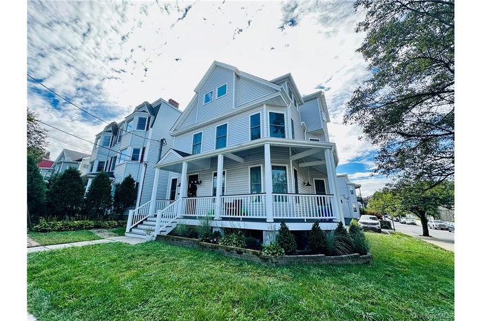 View of front of property featuring a porch and a front lawn