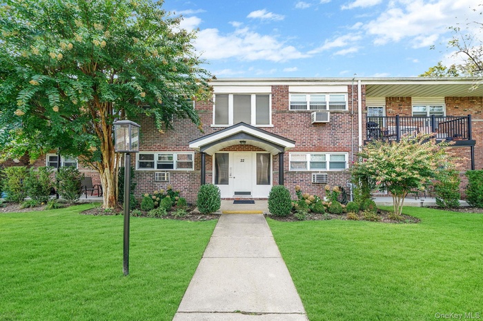 Traditional home with a front yard and brick siding