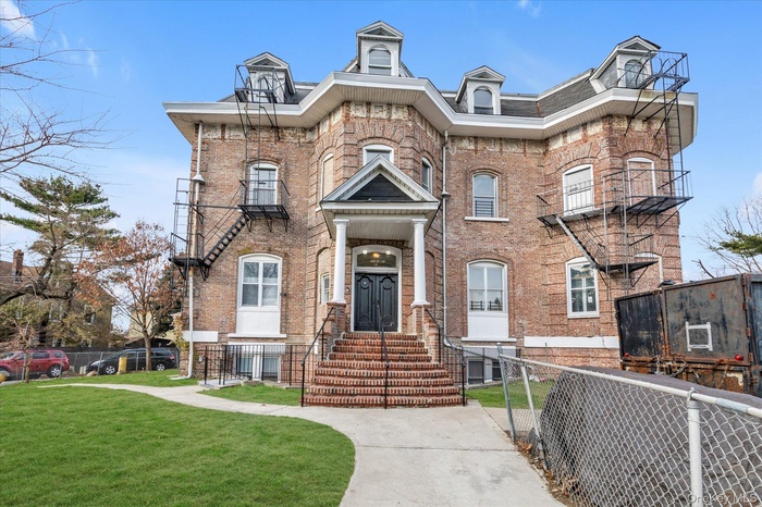 View of front of home with brick siding and a fenced front yard