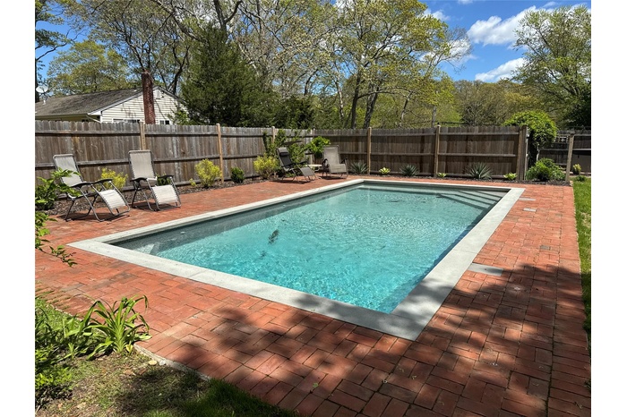 View of swimming pool with a patio area and a fenced backyard