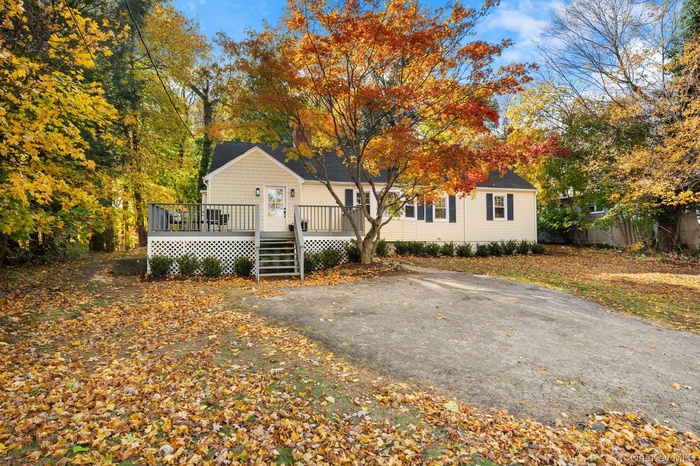 Welcome to 27 Winding Lane — a beautifully renovated home surrounded by vibrant seasonal color, featuring a fresh exterior, new deck, and inviting cur