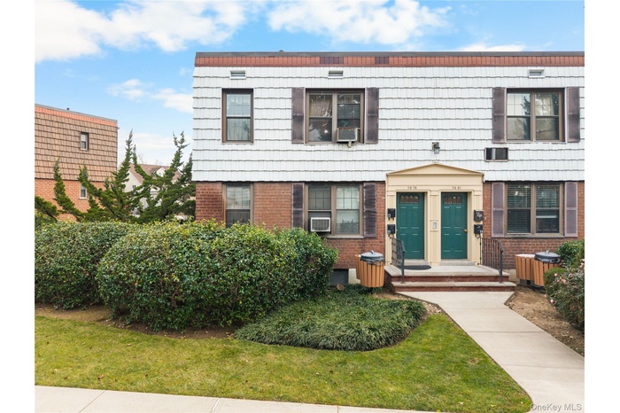 Colonial inspired home featuring brick siding and a front lawn