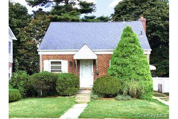 View of front of house with a chimney and brick siding