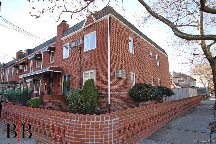 View of home's exterior with brick siding, an AC wall unit, and a chimney