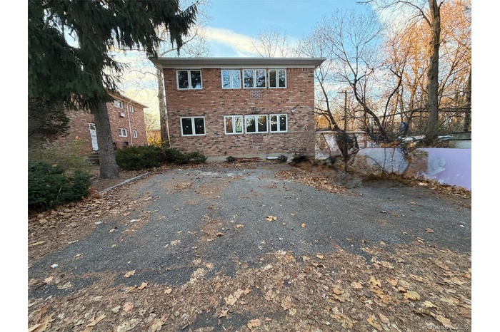 View of front facade featuring brick siding and driveway