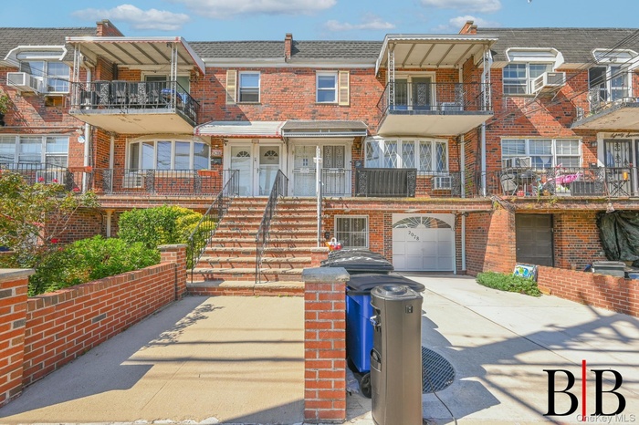Traditional-style house with brick siding, concrete driveway, and a balcony
