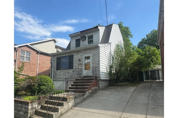 View of front facade featuring stone siding and a shingled roof
