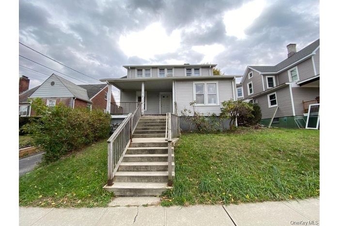 View of front facade with a front yard and covered porch