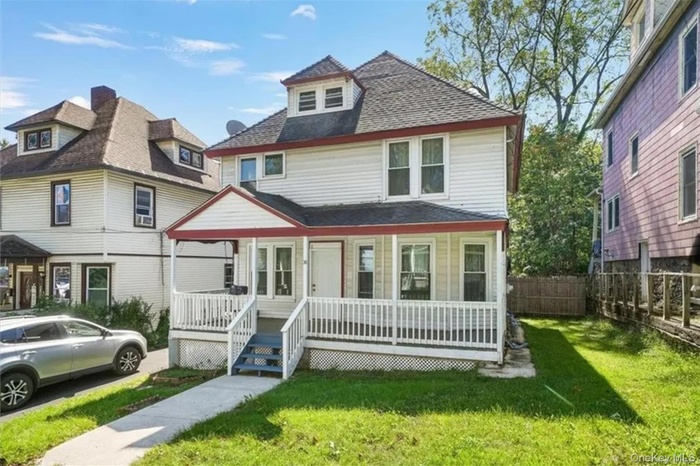 American foursquare style home featuring a wooden deck and roof with shingles