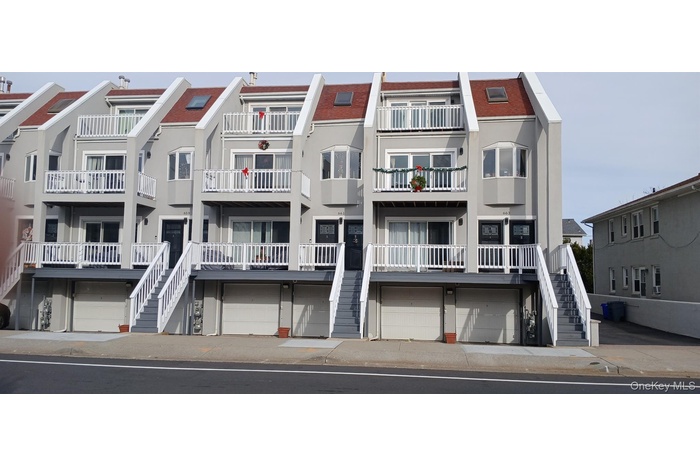View of apartment building / complex with stairway and an attached garage