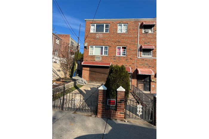 Traditional-style home with brick siding, a gate, and a fenced front yard