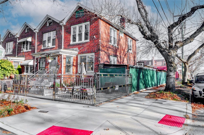 Traditional-style home featuring a fenced front yard, brick siding, and a residential view