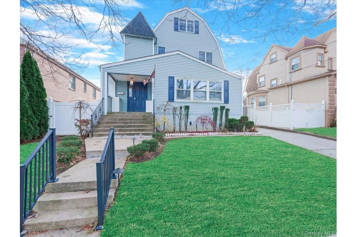 View of front of property featuring a gambrel roof and driveway
