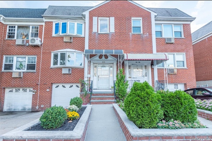 Traditional home featuring brick siding, driveway, and roof with shingles