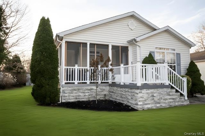 Back of house with a sunroom, a lawn, and a wooden deck