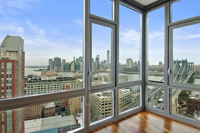 Unfurnished sunroom with a water view, a skyline view, and plenty of natural light