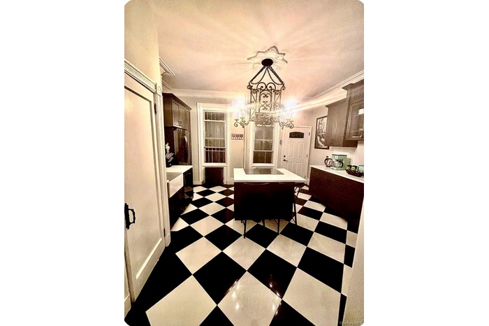Dining space with crown molding and dark flooring