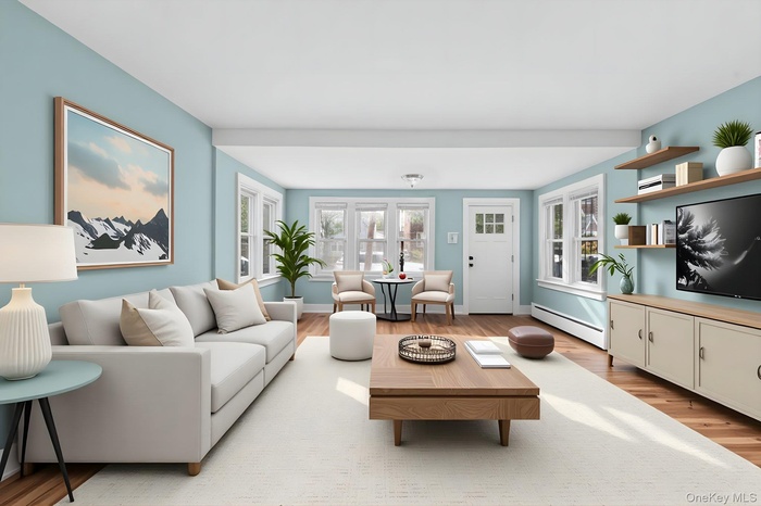 Living room featuring baseboard heating and light wood-style flooring