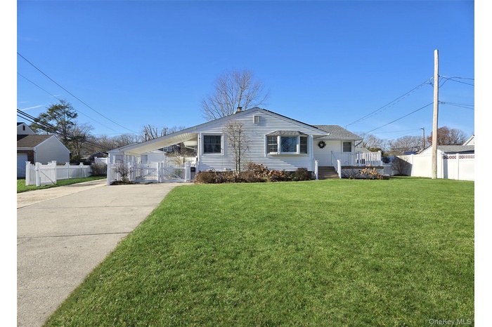 View of front of property with a gate, a deck, and driveway