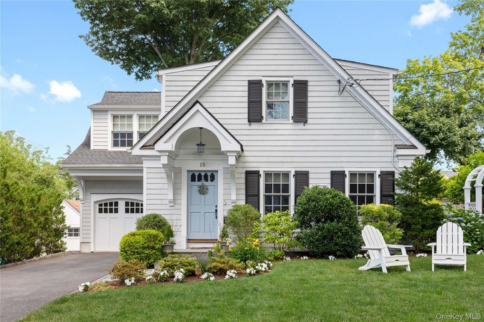 View of front of house with level front lawn, storage room and driveway