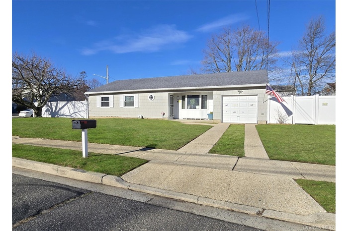 Ranch-style house featuring roof with shingles, covered porch, and an attached garage