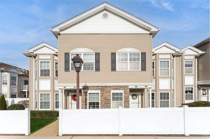 View of front of home with a fenced front yard and stone siding