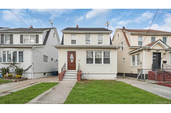 View of front of home with entry steps and a front lawn