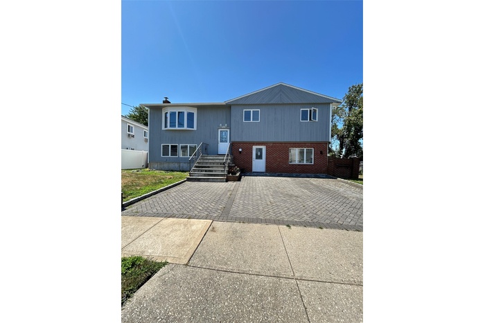 Raised ranch featuring brick siding and a chimney
