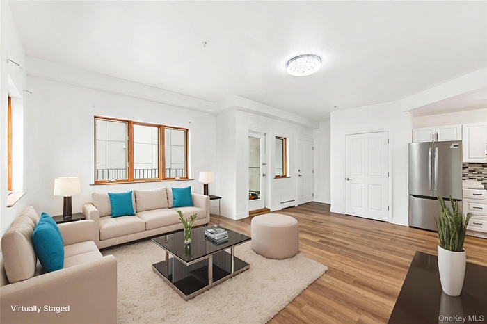Living area featuring light wood-style floors and baseboard heating