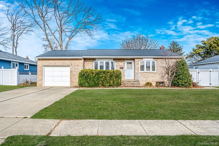 Ranch-style home featuring a garage, concrete driveway, brick siding, and a chimney