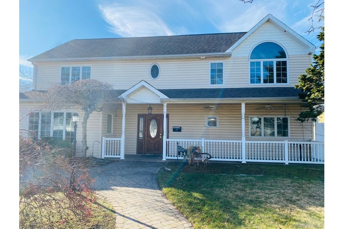 View of front of home featuring covered porch, a front lawn, and a shingled roof