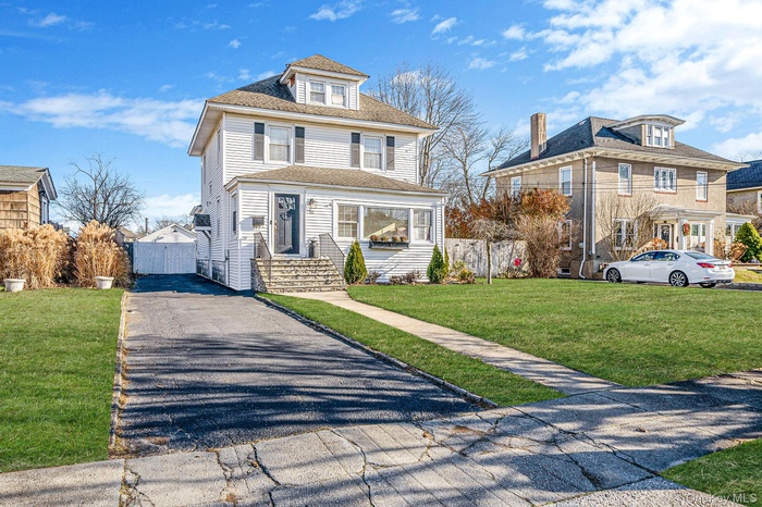Traditional style home with driveway and a shingled roof