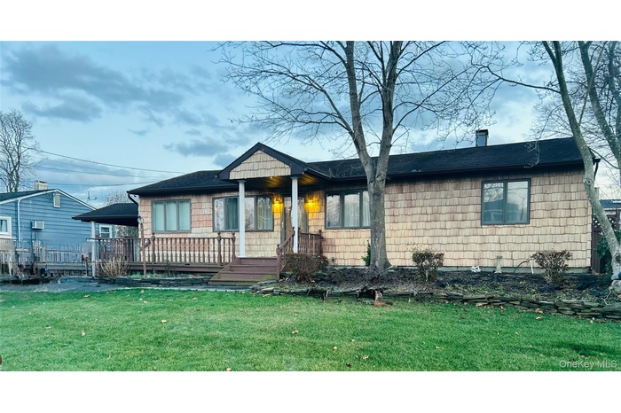 View of front facade with a front yard and a shingled roof