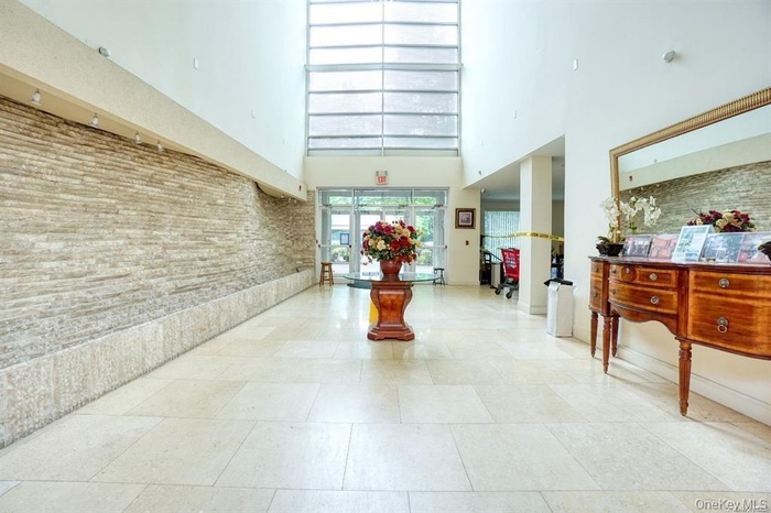 Community lobby with a towering ceiling and brick wall