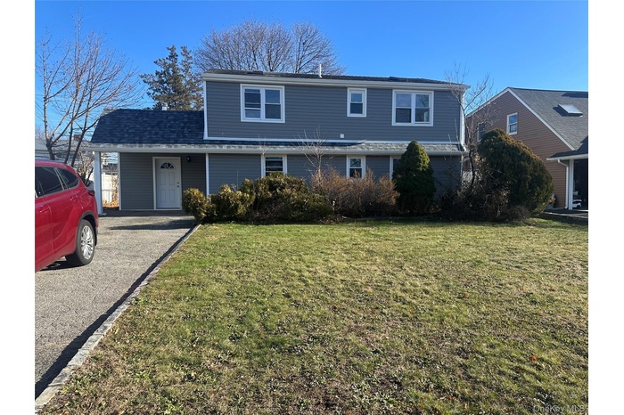 Traditional home featuring a front yard and roof with shingles