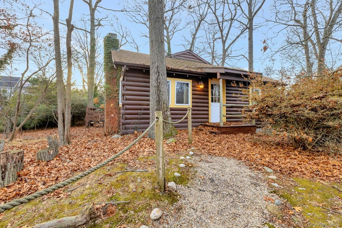 View of front of house with a chimney and faux log siding