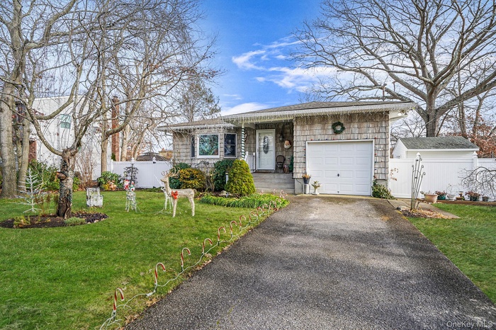 View of front facade featuring asphalt driveway and an attached garage