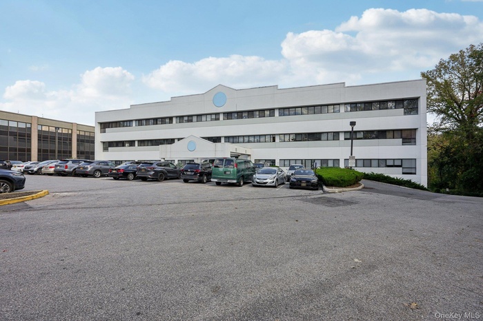 View of apartment building / complex with uncovered parking