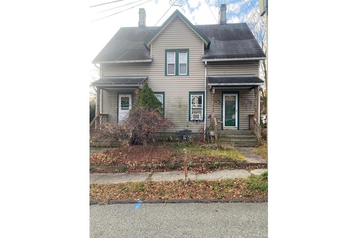 Traditional home featuring a chimney and covered porch