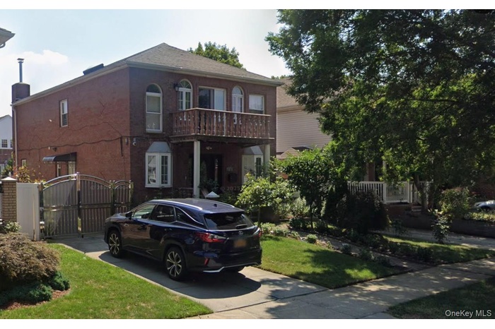 View of front of property with a gate, brick siding, and a front yard