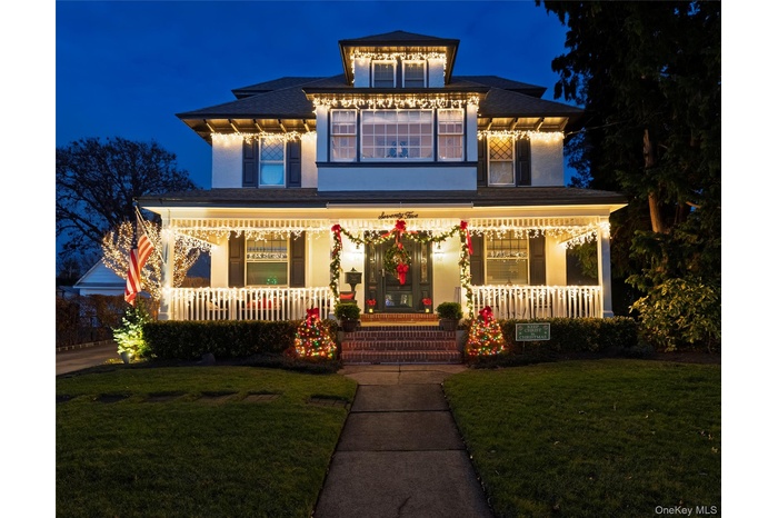 View of front of house with a porch, a lawn, and stucco siding