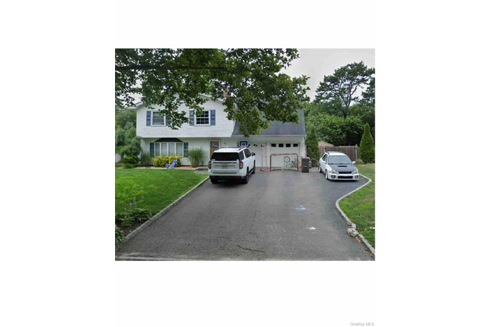 View of front facade with a front lawn and driveway