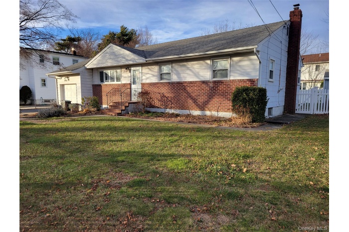 View of front of home featuring brick siding and a chimney