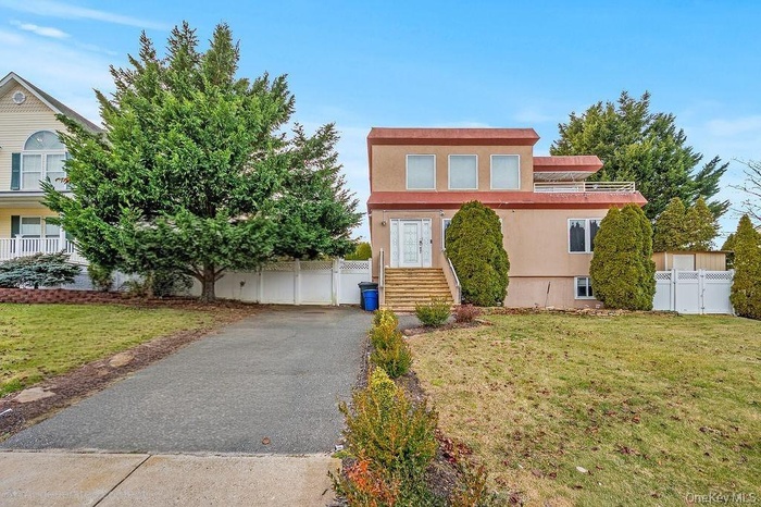 View of front of home with stucco siding and a gate